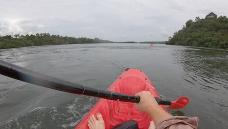 A-point-of-view-shot-of-a-man-on-a-red-kayak-paddling-down-the-Nile-river