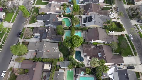Aerial-top-down-forward-over-houses-with-swimming-pool-at-Van-Nuys,-Los-Angeles