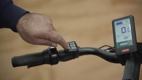 Close-up-of-a-man-adjusting-the-acceleration-strength-of-a-electric-bike-inside-his-shop