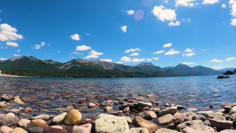Time-lapse-shot-of-tranquil-Lake-with-mountains-in-background-during-beautiful-sunny-day-and-clouds-in-motion