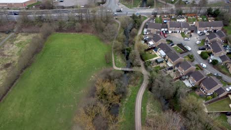 Aerial-view-of-a-river-in-a-park-and-a-large-housing-estate