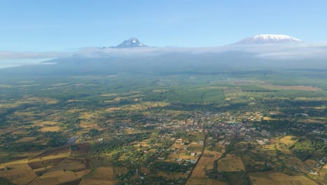 Aerial-view-high-above-rural-Kenya,-Kilimanjaro-background---pull-back,-drone-shot