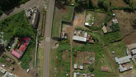 Aerial-view-of-cars,-houses,-yards,-homes-and-village-streets,-on-the-countryside-of-Africa---overhead,-drone-shot
