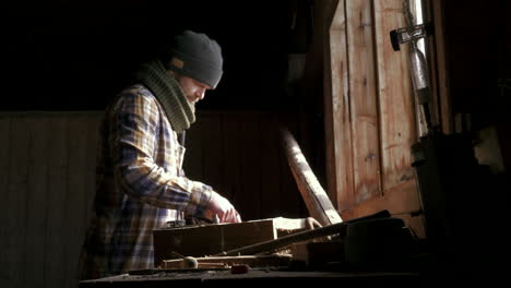 Artisan-inspects-work-tools-with-light-from-window
