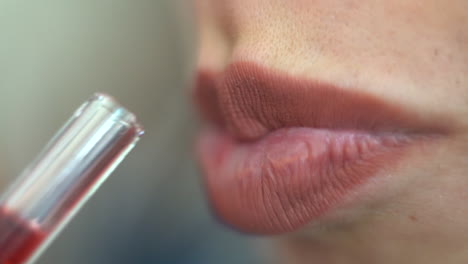 Close-up-of-a-woman's-attractive-lips-drinking-a-red-juice-through-a-straw---Concept:-sexual,-health,-mindful,-juicing,-volume,-voluptuous,-lady