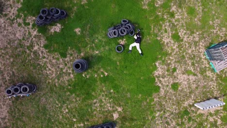 Paintball-player-doing-a-stunt-throwing-himself-on-the-field-while-playing-a-paint-ball-game-drone-shot