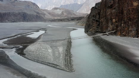 Puente-Colgante-Hussaini-Sobre-El-Río-Hunza,-Gilgit-Baltistán,-Norte-De-Pakistán---Toma-Aérea-De-Drones