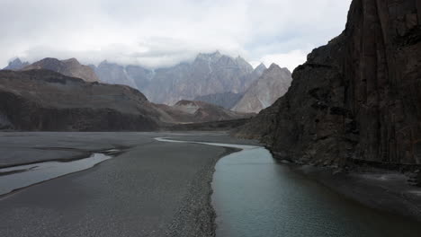 Vista-Del-Puente-Colgante-Hussaini-Sobre-El-Río-Hunza-Con-Picos-De-Montaña-En-El-Fondo-En-Gojal,-Gilgit-Baltistán,-Pakistán