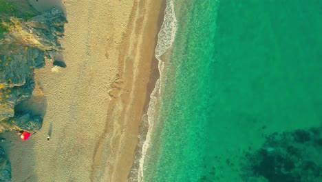 Drone-moving-upwards-at-the-beach,-high-angle-view