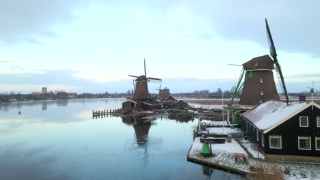 Serene-Zaanse-Schans-with-beautiful-old-Windmills-during-winter-snow,-aerial