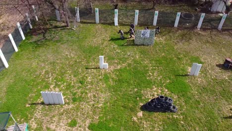 Paintball-players-running-from-their-base-at-the-start-of-the-match-drone-shot