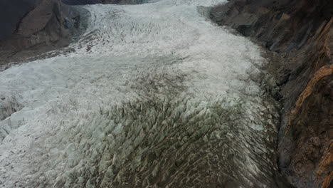 Flying-over-glacier-next-to-Karakoram-Highway,-Hunza-Valley,-Pakistan