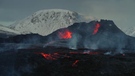Erupción-Geldingadalur-Con-Montaña-Nevada-En-El-Fondo-En-Reykjavik,-Islandia