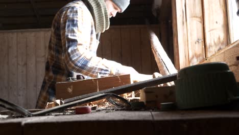 Male-Doing-Hobby-Woodworking-Inside-Workshop-Shed,-Slider,-Medium
