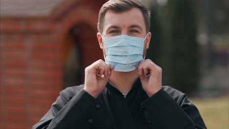 Portrait-of-a-young-priest-wearing-a-medical-mask