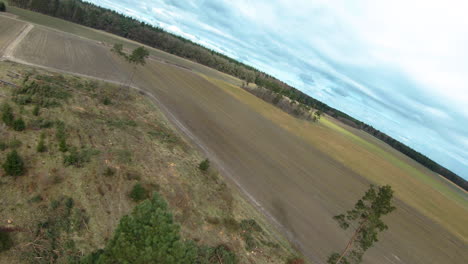 Aerial-fpv-flight-over-agricultural-fields-in-countryside-during-cloudy-and-sunny-day