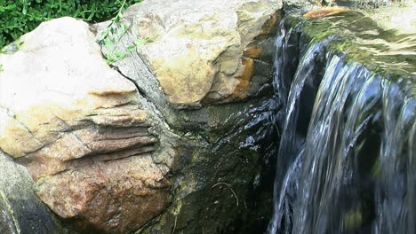 Wasser-Fließt-über-Den-Rand-Eines-Dekorativen-Wasserfalls