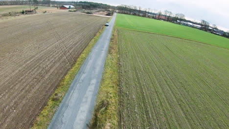 Aerial-top-down-flight-showing-road-between-agricultural-and-rural-fields-outdoors-in-nature