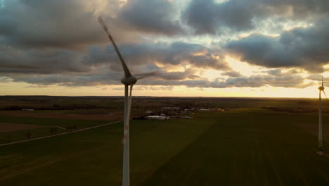 Energie-Erzeugende-Windkraftanlagen,-Die-Sich-In-Malerischer-Sonnenuntergangsansicht-Drehen---Luftaufnahme
