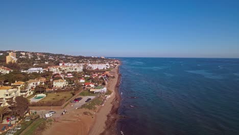 Aerial-view-of-coastline-of-Spain,-moving-backwards-and-closer-into-the-beach