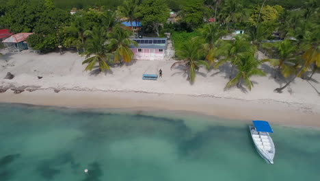 Luftaufnahme-Von-Palmen,-Booten-Und-Häusern-In-Der-Stadt-Mano-Juan-Auf-Der-Insel-Saona-In-Der-Dominikanischen-Republik---Verfolgen,-Drohnenaufnahme-Nach-Oben-Kippen