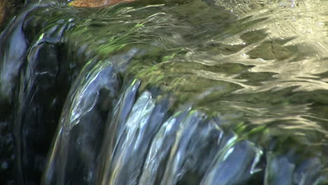 Close-up-of-water-flowing-over-the-brink-of-a-small-waterfall