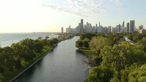 Drone-Rises-to-Reveal-Chicago-Skyline,-Lincoln-Park,-and-Lake-Michigan-during-Beautiful-Summer-Sunset