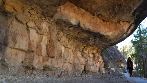 Female-Hiker-Exploring-Cliff-Dwellings-At-Walnut-Canyon