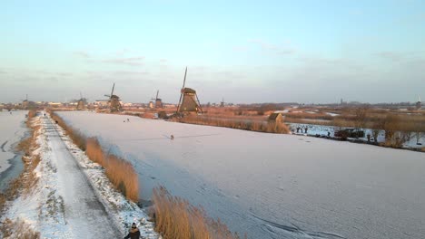 Wintertime-at-Kinderdijk-windmills-with-tranquil-morning-sunlight,-aerial