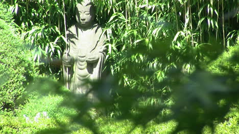 Focus-Pull-Von-Japanischen-Ahornblättern-Im-Vordergrund-Zur-Buddhistischen-Jizo-Statue-Im-Hintergrund