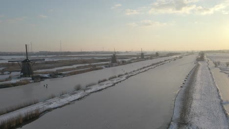 Winterzeit-In-Den-Berühmten-Windmühlen-Von-Kinderdijk-Mit-Zugefrorenem-Fluss,-Sonnenaufgang