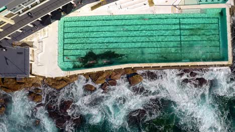 Swimmers-At-The-Famous-Bondi-Icebergs-Ocean-Pool-During-Daytime-In-Bondi-Beach,-NSW,-Australia---aerial,-top-down