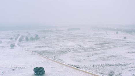 Drone-flying-in-snowstorm-over-vast-land-all-covered-with-snow