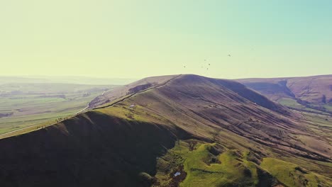Aerial-View-Over-Paragliders-Flying-And-Landing-At-Mam-Tor,-England