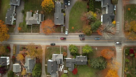 Top-Down-Aerial-shot-of-residential-homes-in-a-small-town-during-Autumn-leaves