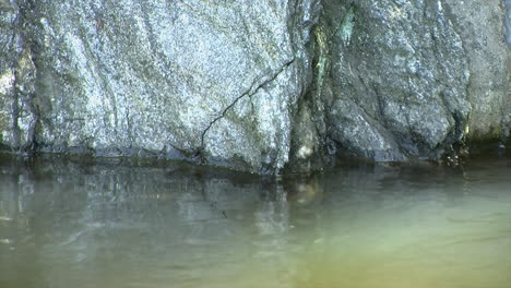 Nahaufnahme-Von-Glänzenden-Felsen-Am-Rand-Des-Wassers