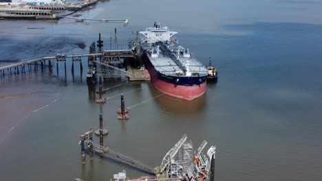 Crude-oil-tanker-ship-loading-at-refinery-harbour-terminal-aerial-view-reverse-above-platform