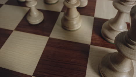 Closeup-of-Player-Hand-Moves-White-Knight-Chess-Piece,-looking-down-perspective