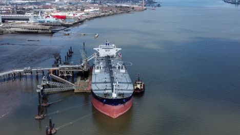Crude-oil-tanker-ship-loading-at-refinery-harbour-terminal-aerial-high-angle-view