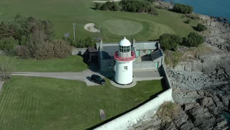 Aerial-orbit-shot-of-lighthouse-during-calm-and-sunny-day,-wide-angle