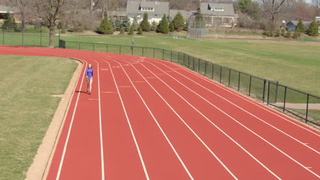 Teen-girl-walking-on-a-track-towards-camera-in-slow-motion