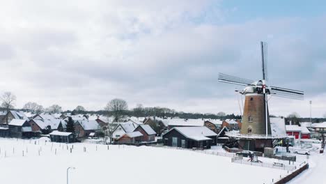 Small-Village-in-Veluwe-National-Park-Covered-in-Snow,-Low-Aerial-Dolly-Right