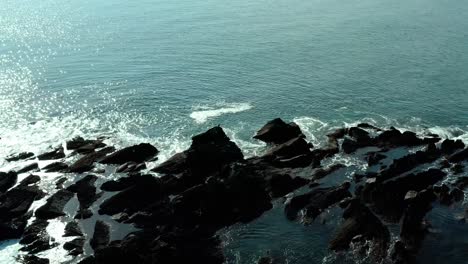 birds-eye-view-of-ocean-waves-near-rocks-at-ocean-in-summer-at-day