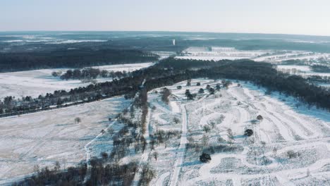 High-Aerial-View-of-Snow-Covered-Landscape-with-Forests-and-Highway