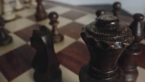 Rotating-Chess-Board-as-Black-King-and-Queen-Chess-Pieces-Come-into-View,-closeup