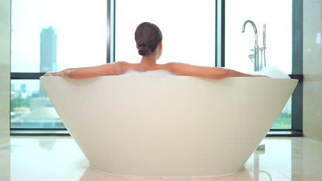 Rear-View-of-Woman-in-Luxurious-Bathtub-Enjoying-City-View