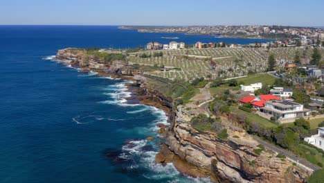 Aerial-View-Of-Blue-Sea,-Coastal-Suburb-And-Waverley-Cemetery-At-Daytime-In-Bronte,-NSW,-Australia