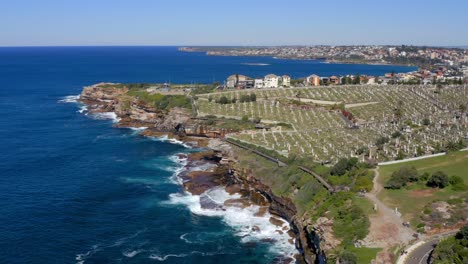 Tiefblaues-Meer-Mit-Gefährlichen-Wellen,-Die-Auf-Klippen-Mit-Waverley-Friedhof-In-Bronte-In-Sydney,-New-South-Wales,-Australien-Zusammenbrechen