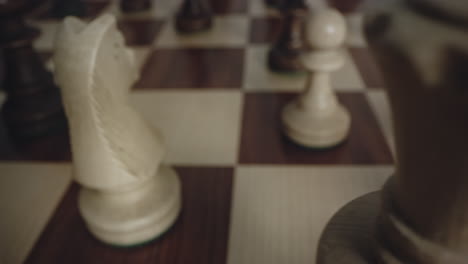 Nahaufnahme-Von-Schachfiguren-Aus-Weißem-Holz-Kommen-In-Sicht,-Wenn-Sich-Das-Schachbrett-Dreht