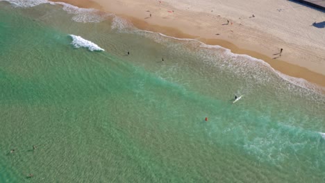 Idyllic-Beach-With-Turquoise-Water-And-Fine-Sand---Bondi-Beach-With-Tourists-And-Surfers-Enjoying-In-Sydney,-New-South-Wales,-Australia---aerial-drone-shot